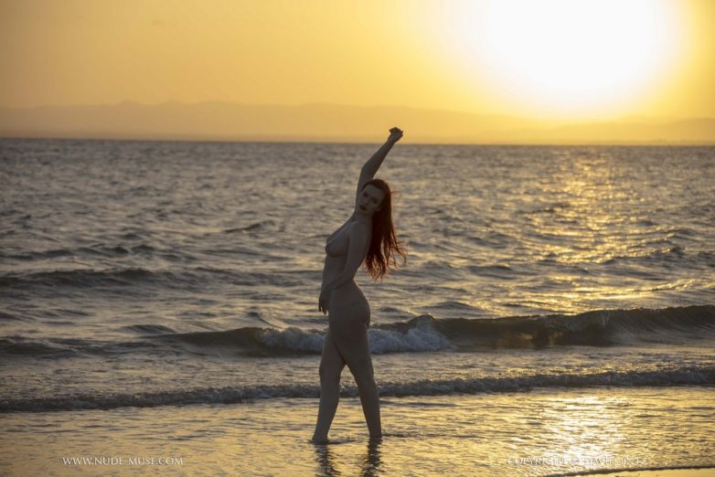 Девушка с огненно-рыжими волосами в лучах заходящего солнца