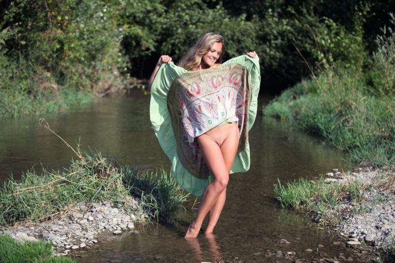 Девушка с красивой натуральной грудью снимается обнажённой в реке