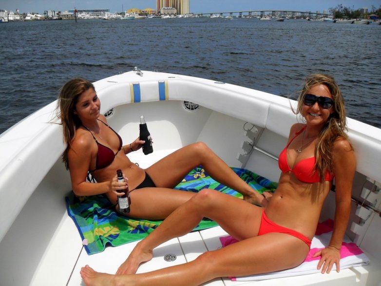 Девушки в бикини наслаждаются летним отпуском на лодках